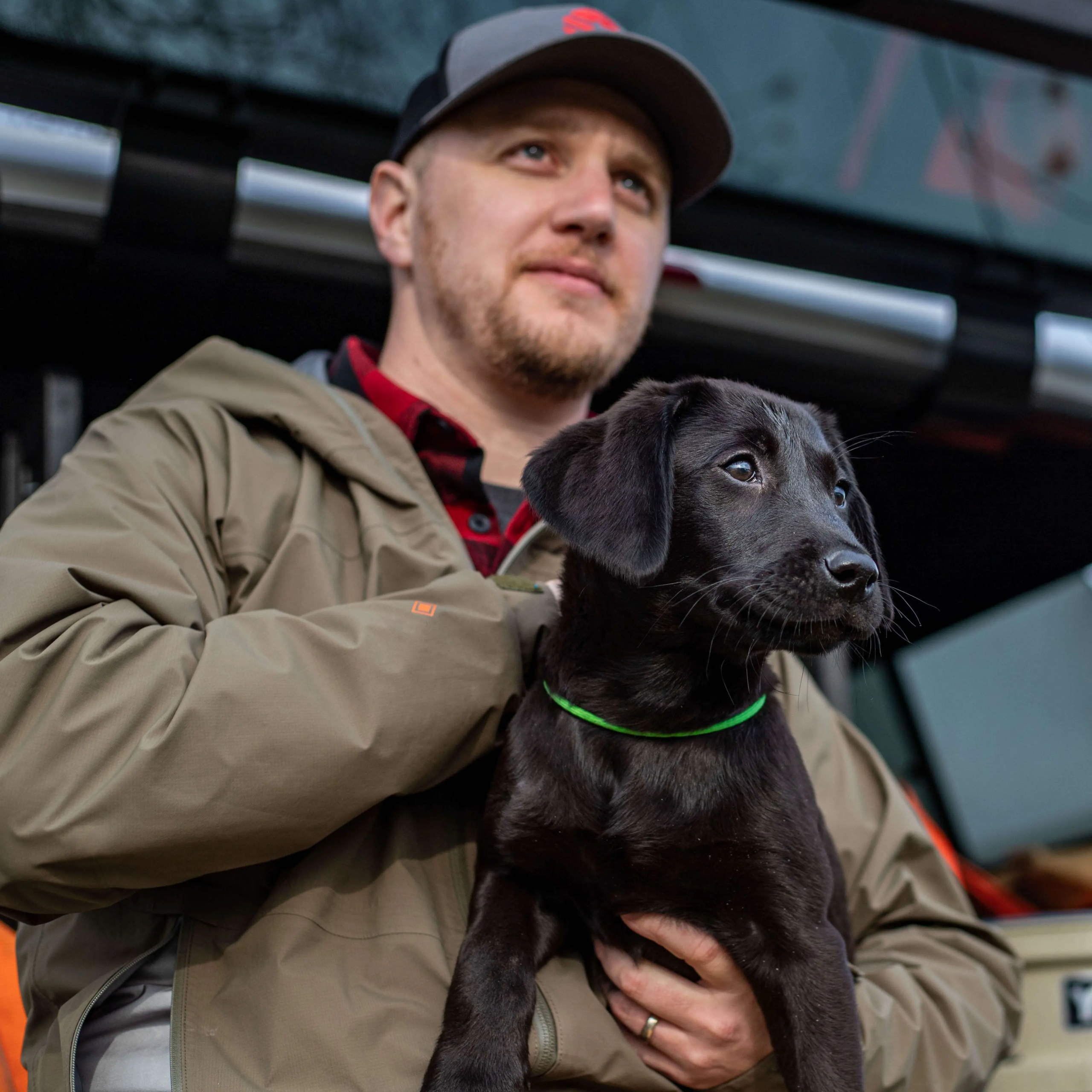 Joe Scott, founder of Zero Tolerance Labs, holding a black Labrador puppy
